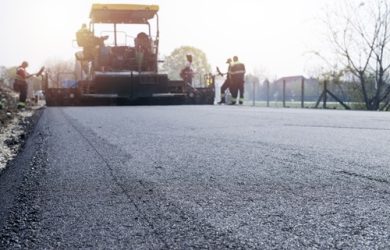 Workers placing new coating of asphalt on the road. Workers placing new coating of asphalt on the road.